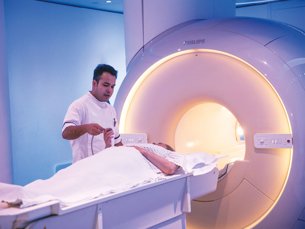 A patient prepares for an MRI scan; ?>