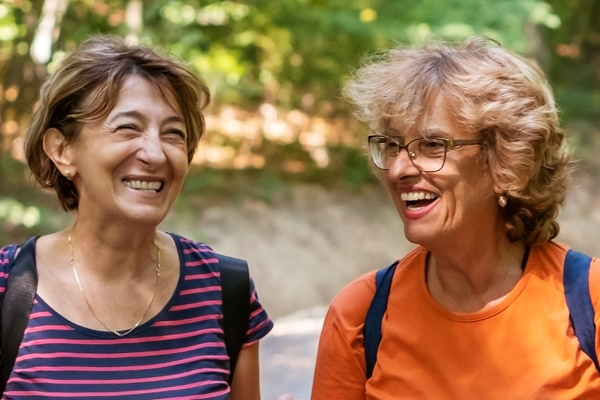 A picture of two older females outside laughing; ?>