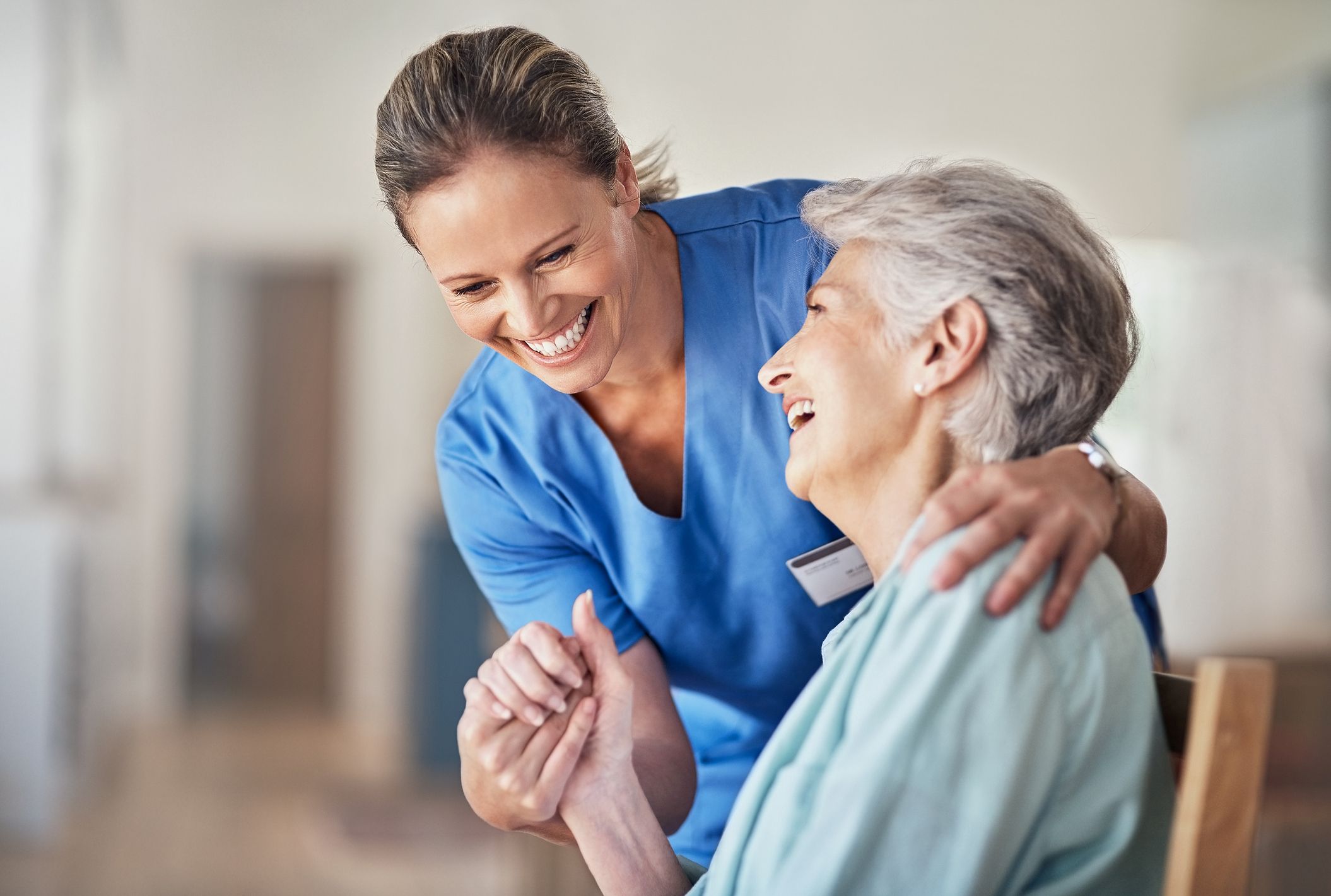A nurse holding hand of an older patient