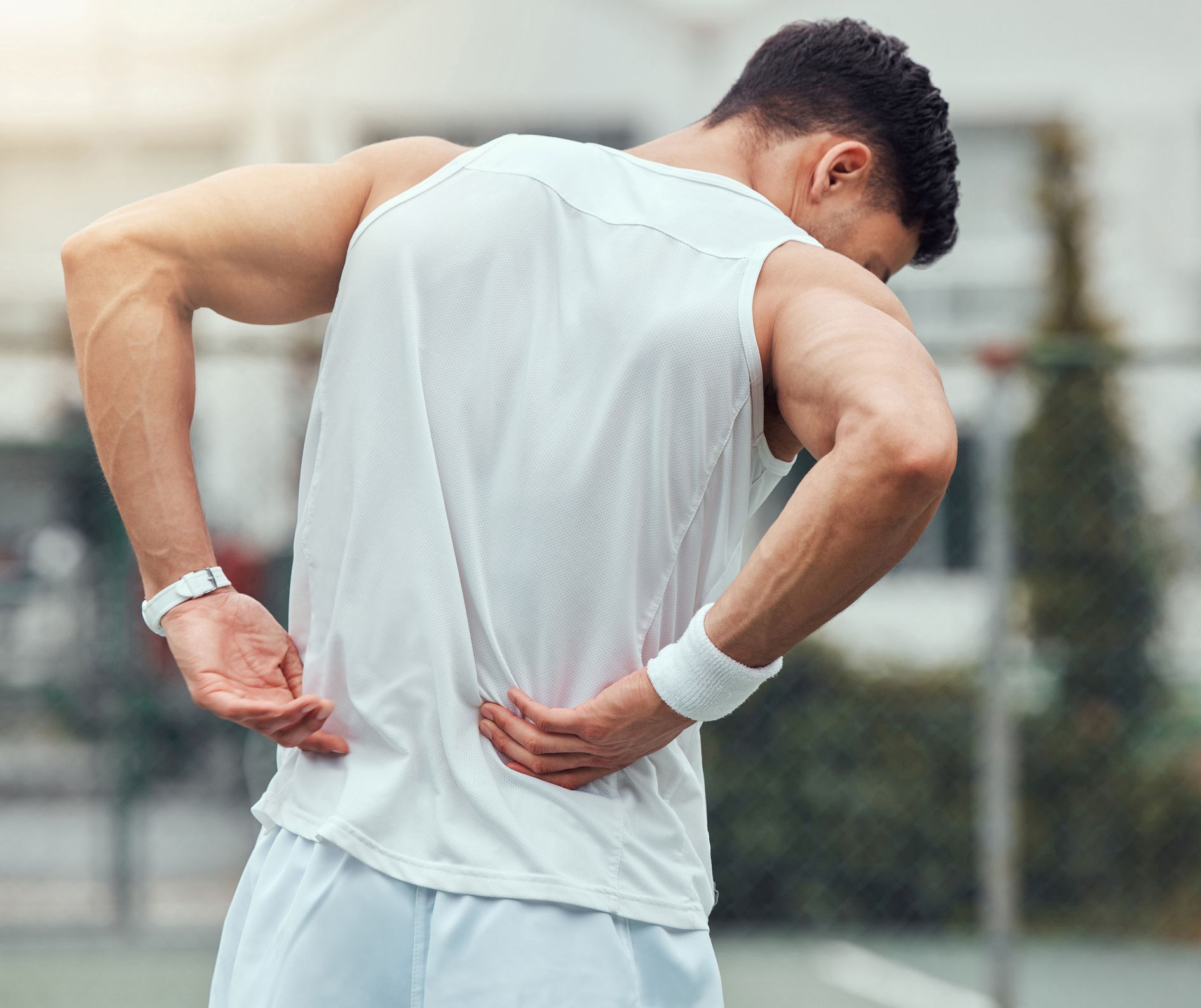 Younger male in running clothes holding onto his back